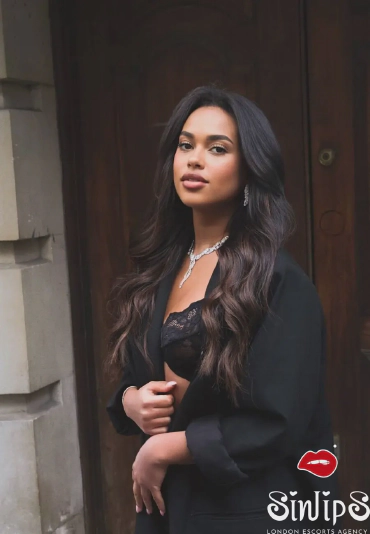 Galushka, a dark chocolate delight escort in London of Ukranian origins looking stunning in a black bra and business outfit